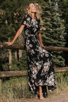 Back view of black floral maxi dress highlighting the keyhole-and-button closure at the nape and elastic back waist.