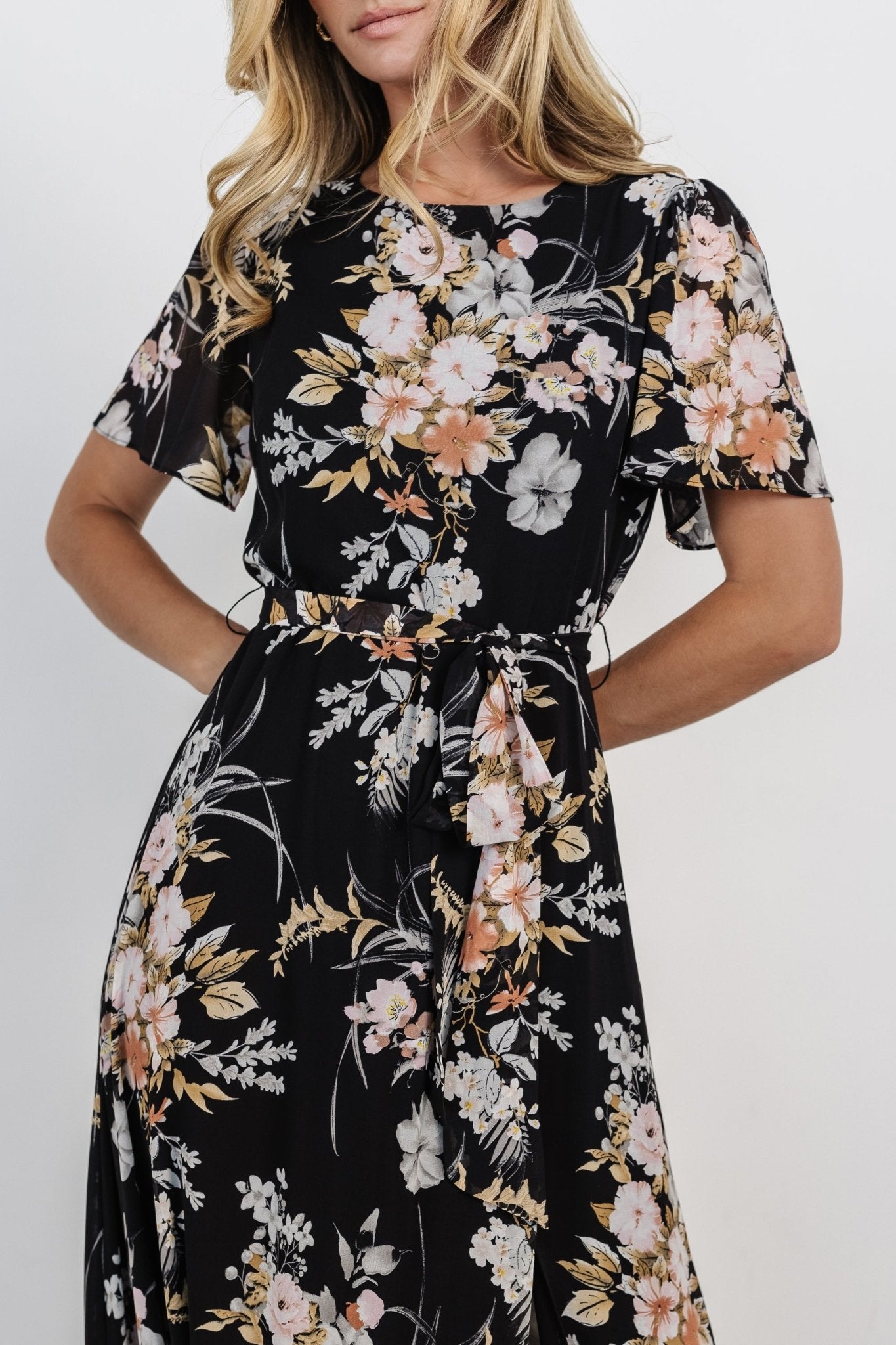 Close-up of chiffon fabric and muted coral, pink, grey and caramel floral print showing texture and drape of the skirt.