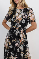 Close-up of chiffon fabric and muted coral, pink, grey and caramel floral print showing texture and drape of the skirt.