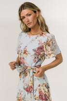 Side view of Naomi chiffon maxi dress in blue multi floral on model, highlighting flutter sleeve and flowing skirt movement.