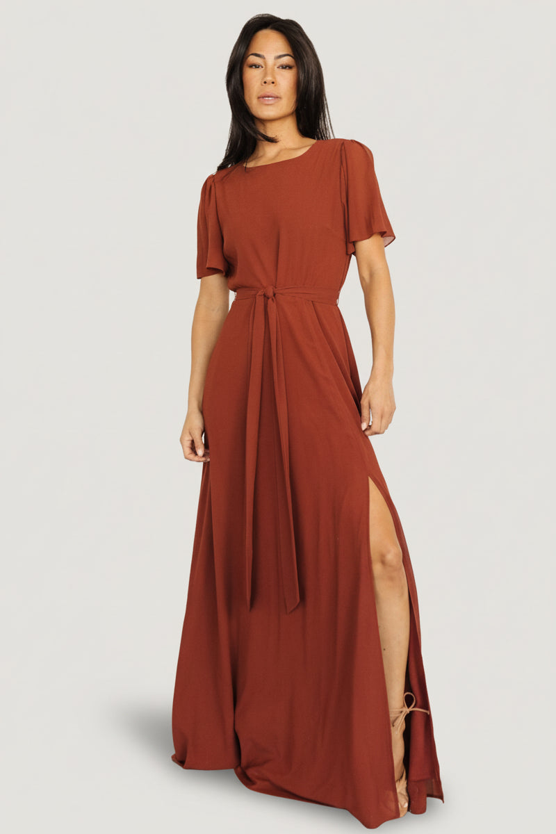 Front view of Naomi cinnamon chiffon maxi dress on a model showing rounded neckline, short flutter sleeves and flowing skirt.