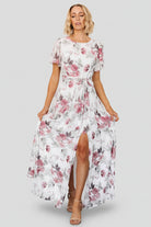 Front view of Naomi off-white maxi dress with rose and sage floral print, rounded neckline, short flutter sleeves, and removable waist tie.
