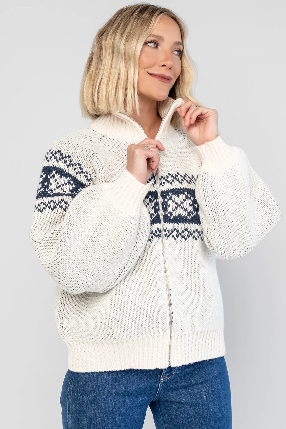 Neve Sweater Jacket in Cream + Navy with a Fair Isle knit pattern, turtleneck, silver zip-front design, and cozy thick knit.