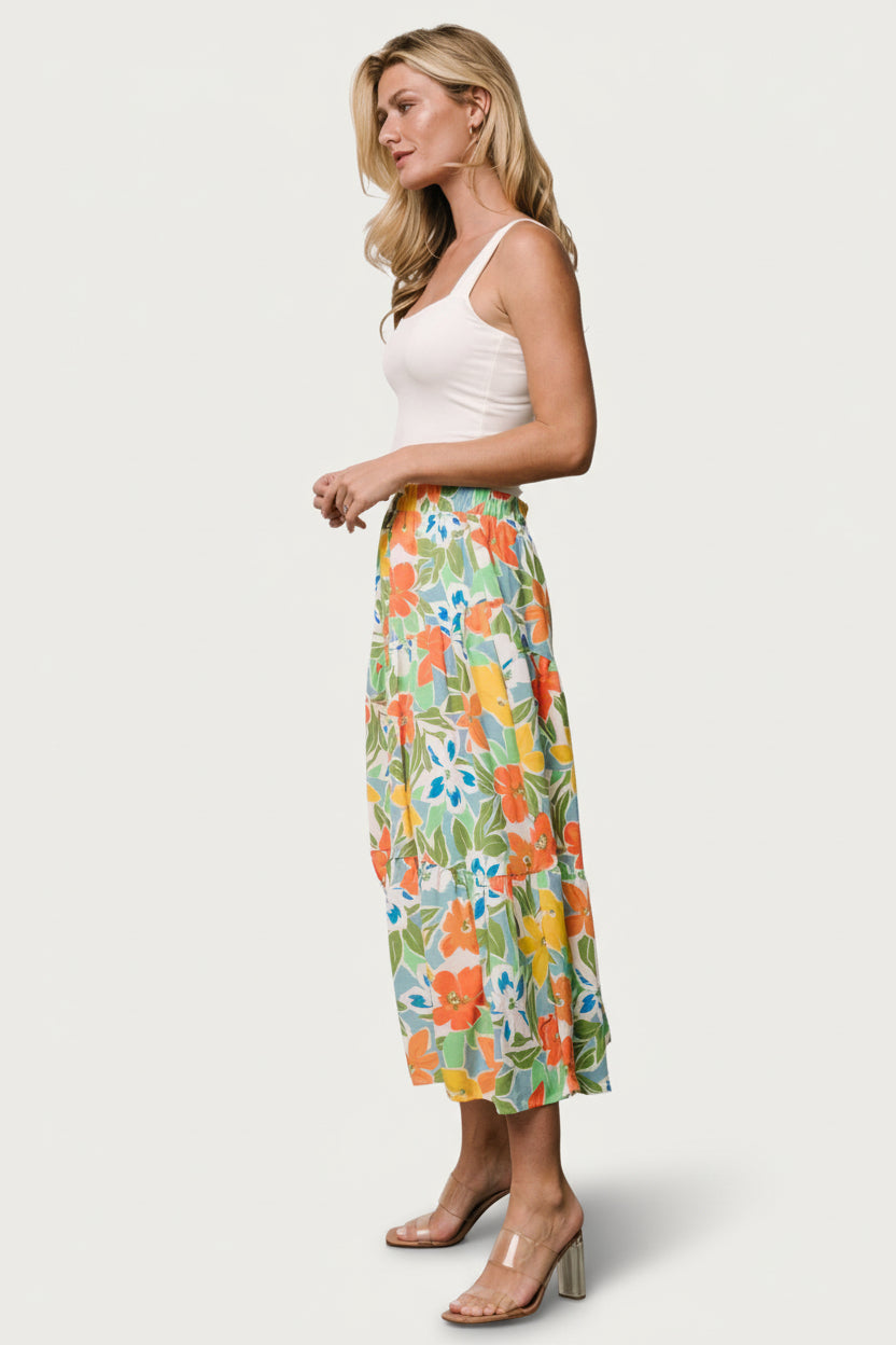 Side view of the asymmetrical tiered skirt in orange and blue floral, displaying layered hem movement and full lining.