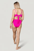 Flat-lay of hot-pink ribbed bikini bottom showing silhouette, mid-rise band, and fully lined interior for opacity and comfort.