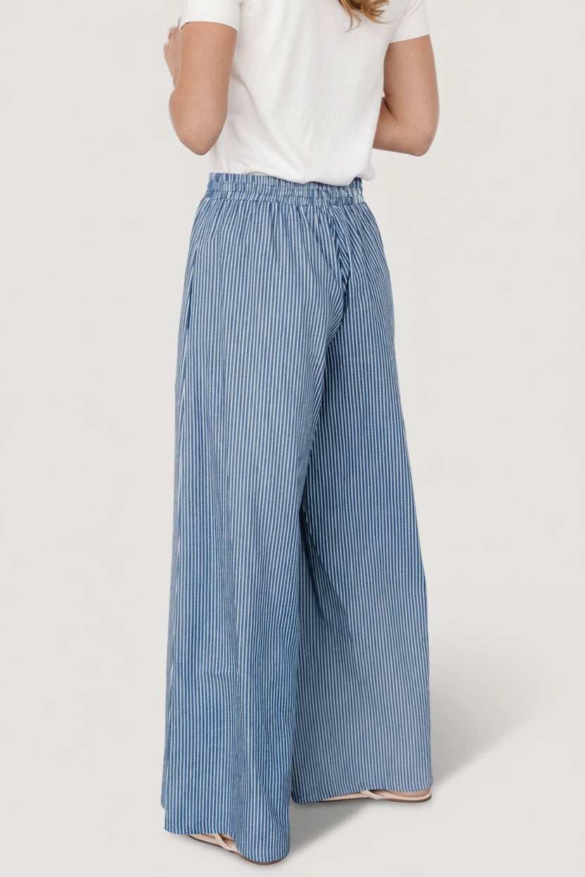 Studio shot of Odelia striped pants laid flat showing full-length silhouette, vertical stripe pattern, and unlined cotton fabric details.