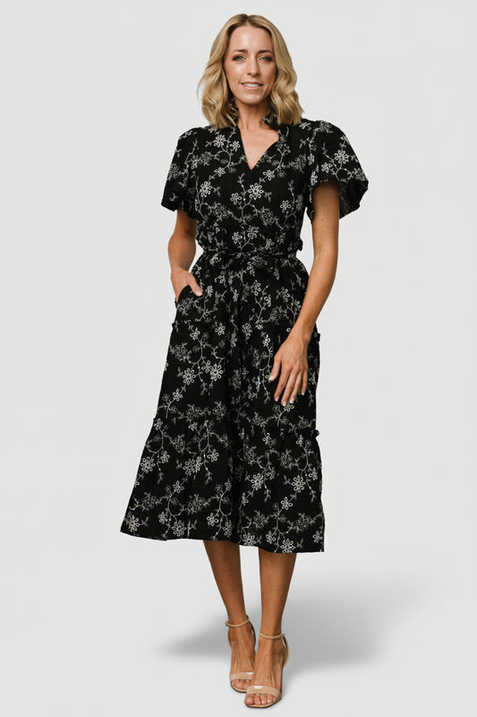 Front view of Odeya tiered midi dress in black-and-white floral cotton, showing ruffled V-neck and short sleeves.