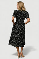 Back view of Odeya tiered midi dress showing ruffle details along the tiered skirt in black-and-white.