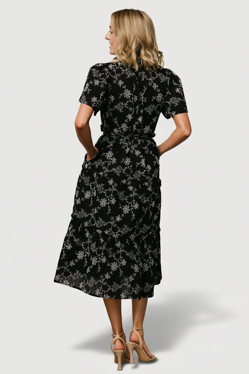 Back view of Odeya tiered midi dress showing ruffle details along the tiered skirt in black-and-white.