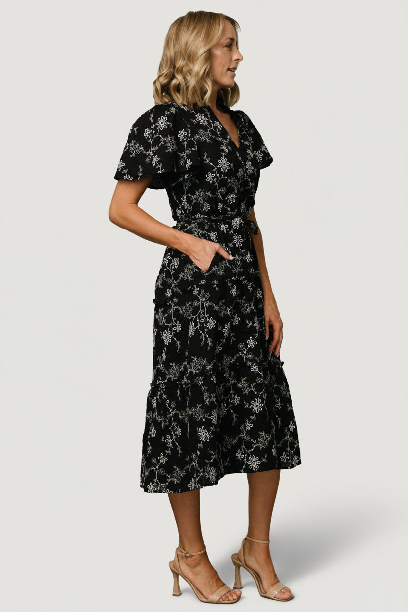 Detail shot of the Odeya dress ruffled V-neck and short sleeve silhouette in black-and-white floral cotton.