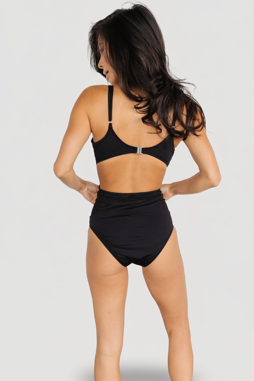 Back view of Odyssey one-piece in black displaying mesh cutout across the upper back and flattering high-waist silhouette.