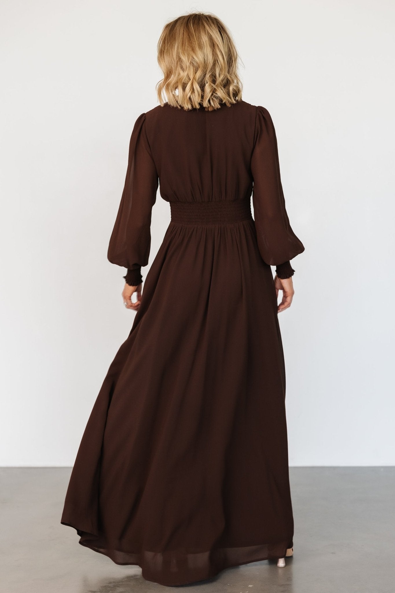 Movement shot of Olivia maxi dress in deep espresso brown, highlighting lightweight chiffon and full-length hem.