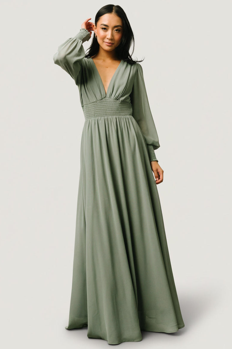 Front view of Olivia Maxi dress in eucalyptus green, chiffon fabric, deep V-neck, smocked waist and long sleeves; full-length silhouette.