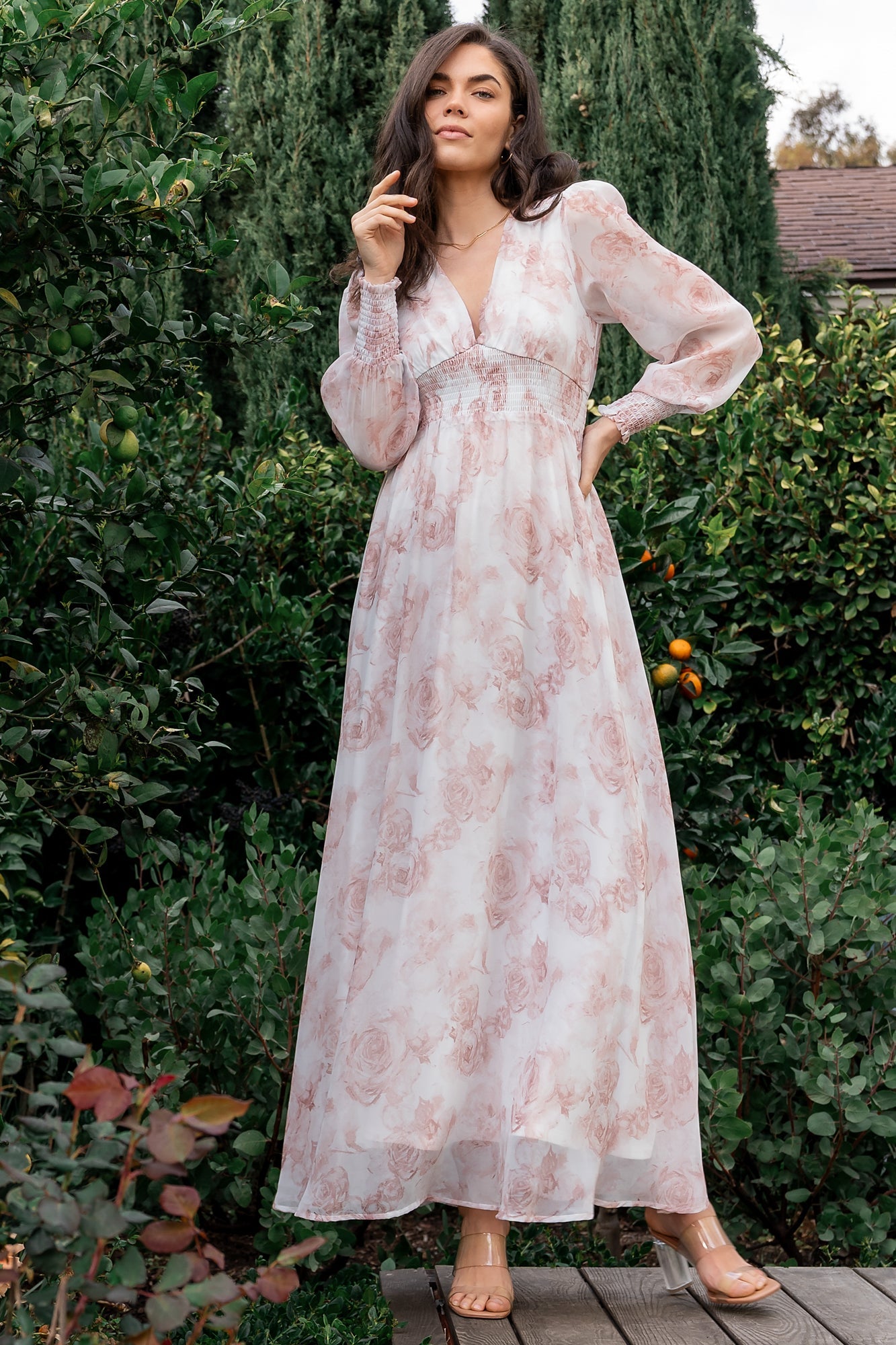 Back view of pink floral chiffon maxi dress with flowing skirt and smocked waist visible, demonstrating movement and coverage.