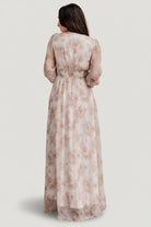 Side profile of pink floral chiffon maxi dress showing silhouette, full-length skirt, and smocked cuff detail at the sleeve.