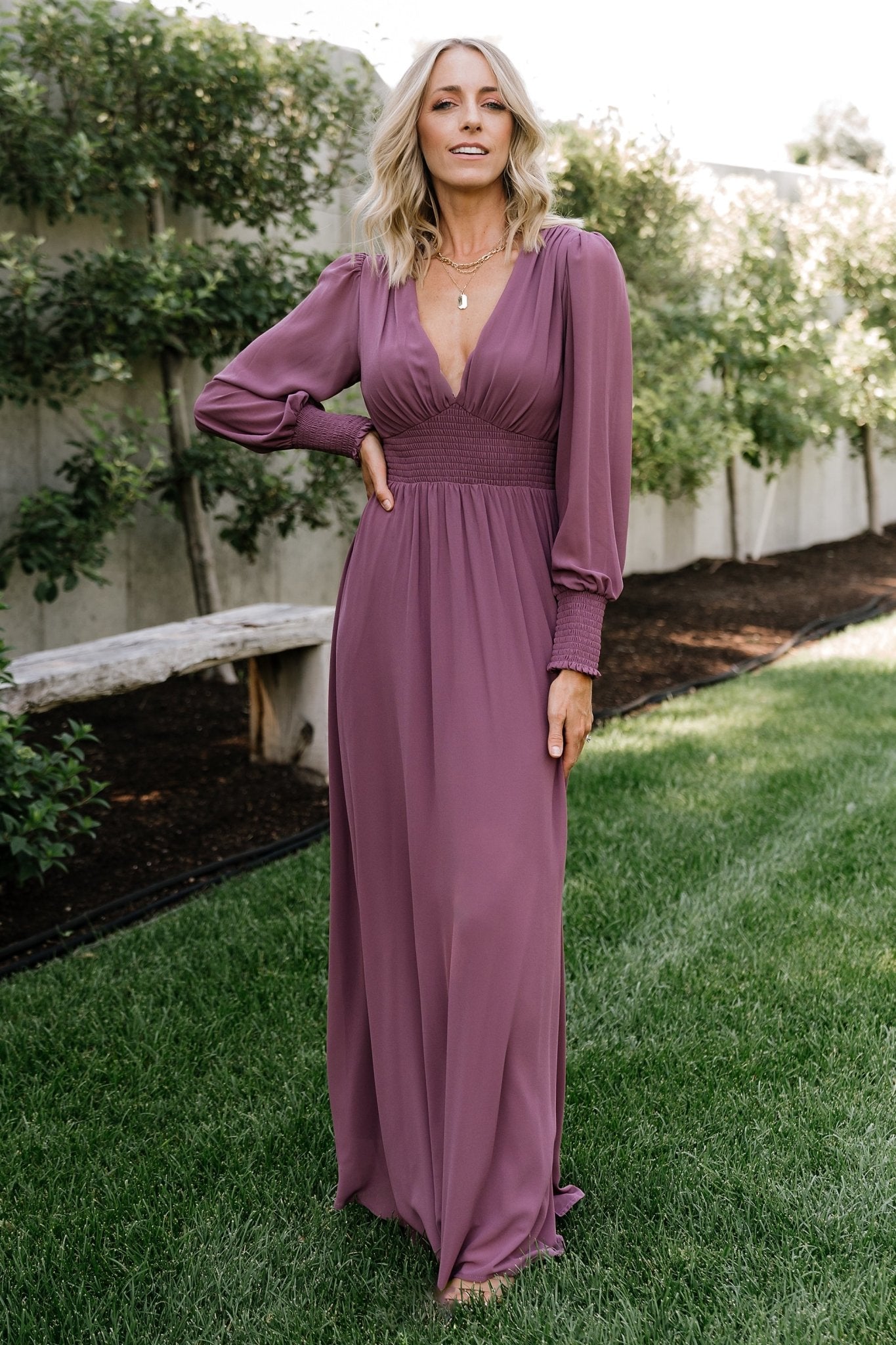 Side profile of Olivia Maxi Dress in vintage plum, showing smocked waist, gentle drape, and maxi-length silhouette on model.