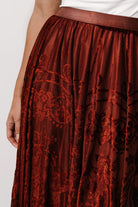 Close-up of Palini skirt fabric showing velvet burnout pattern over rust lining and soft mesh texture.