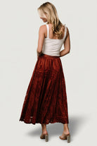 Side view of Palini Velvet Skirt in rust demonstrating drape, movement, and elastic waistband detail.