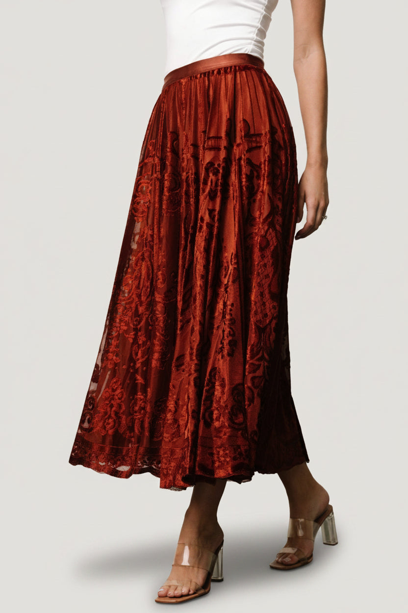 Styled outfit photo featuring Palini Velvet Skirt in rust paired with a fitted top and lightweight jacket.
