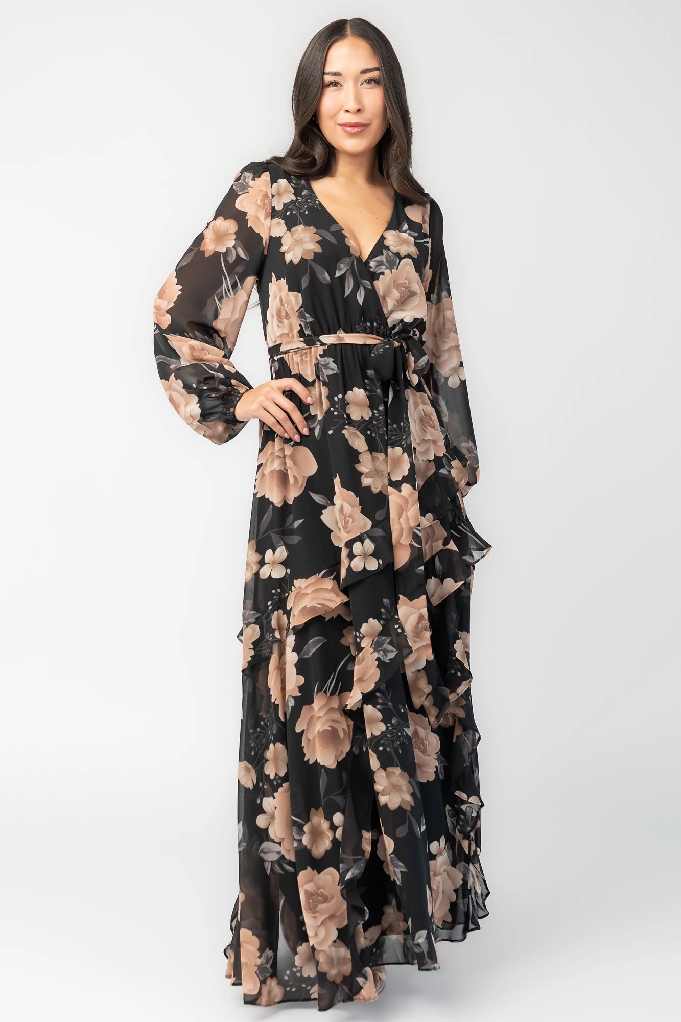 Phaedra Maxi Dress in Black + Taupe Floral with surplice V-neck, long sleeves, sash waist, and tiered skirt.