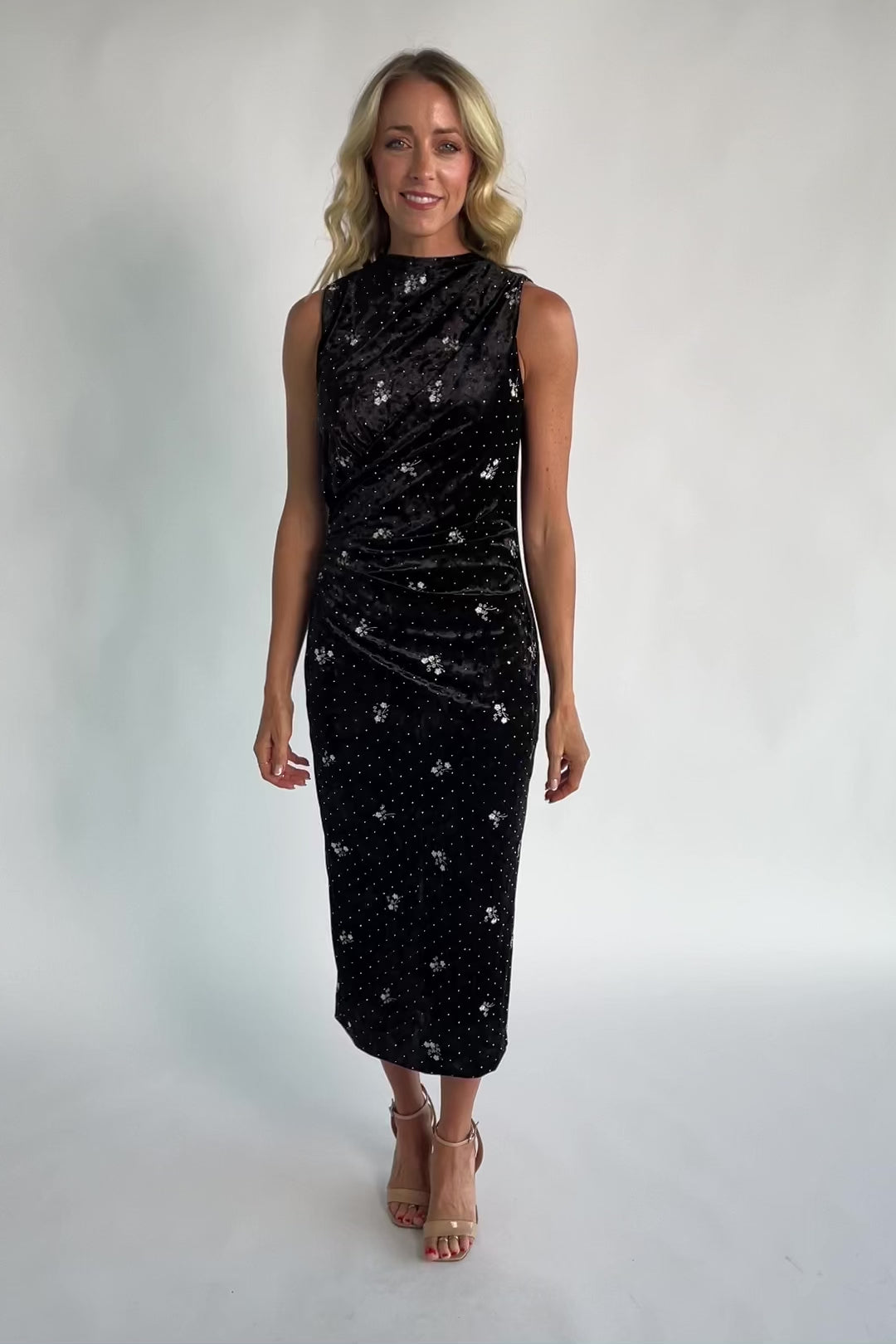 Model wearing a black velvet midi dress with a high neckline and fitted silhouette.