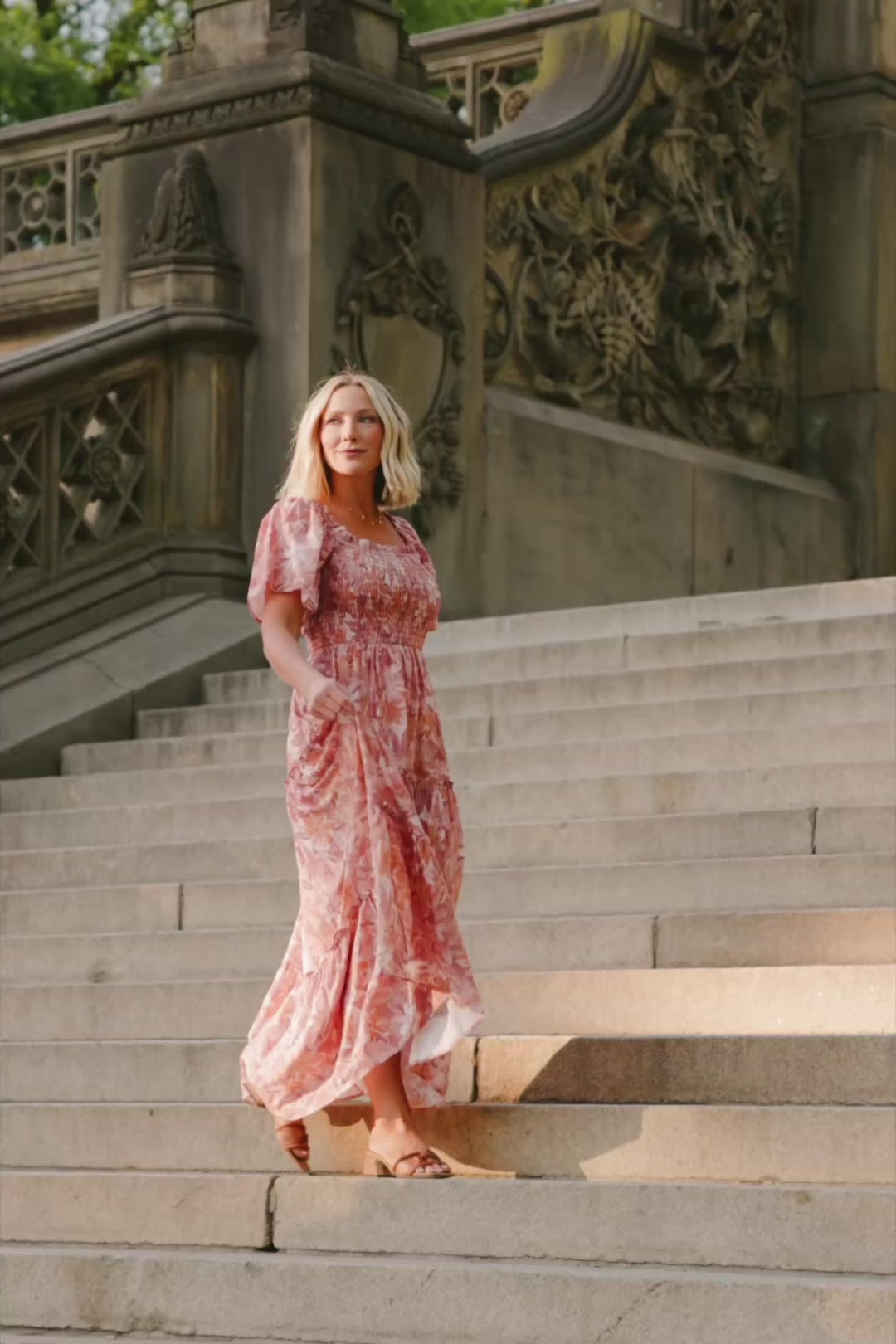 Model wearing the Southampton Smocked Maxi Dress in Dusty Mauve Floral featuring a square neckline, flutter sleeves with ruffle trim, a fully smocked bodice, and a flowing tiered maxi skirt with a dusty mauve floral print.