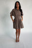 Model wearing a brown plaid short dress with a collared neckline, button-front closure, and short dolman sleeves.