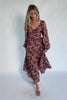 Model wearing a dusty mauve floral maxi dress with a sweetheart neckline, adjustable tie-front bust, and long sheer sleeves.