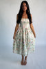 Model wearing a cream floral midi dress with a square neckline, adjustable shoulder tie straps, fitted bodice, and flowing skirt. 