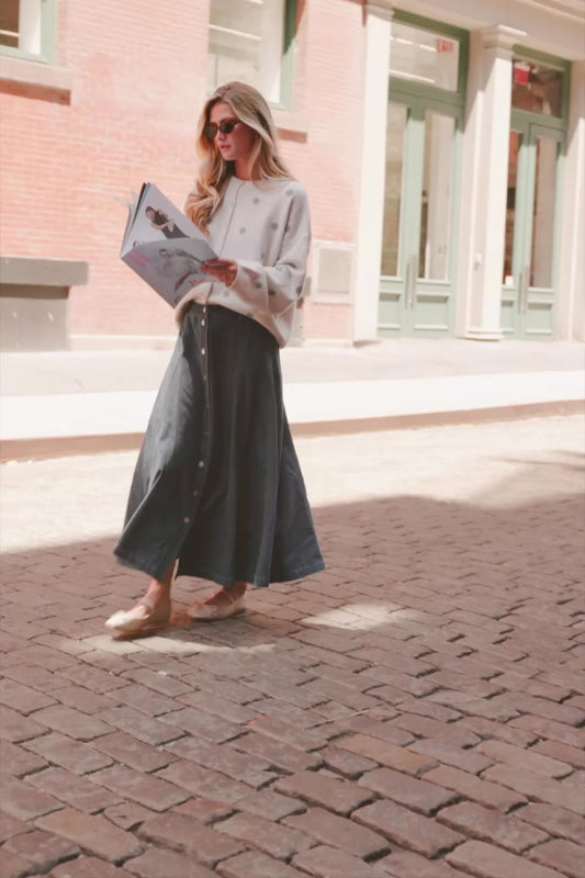 Model wearing the Cece Button-Down Denim Skirt in a dark wash featuring a button-front placket, elastic back waist, and a classic knee-length silhouette.