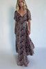 Model wearing a gray floral maxi dress with a sweetheart neckline, flutter sleeves, and a smocked back bodice.