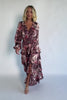 Clove satin maxi dress with a mauve floral print, V-neckline, short sleeves, a smocked back, and a flowing tiered ruffle skirt.