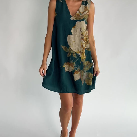 Deep topaz floral shift dress with a V-neckline, sleeveless silhouette, side pockets, and a relaxed above-the-knee fit.