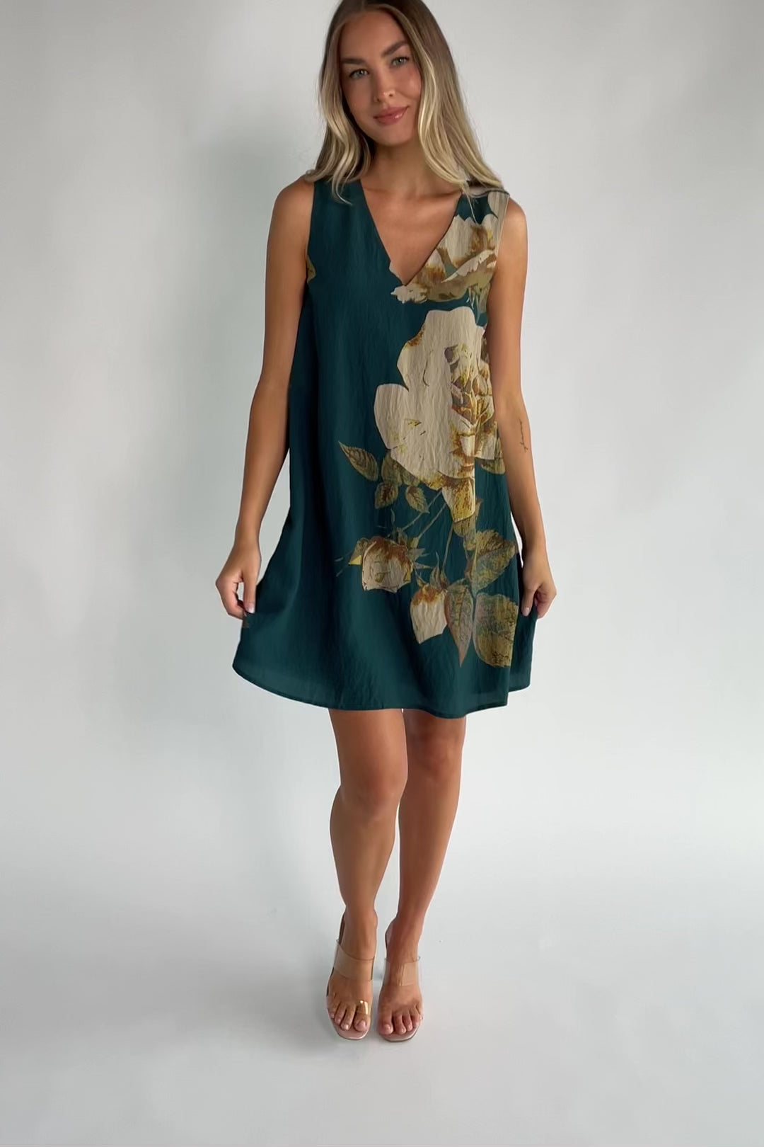 Deep topaz floral shift dress with a V-neckline, sleeveless silhouette, side pockets, and a relaxed above-the-knee fit.