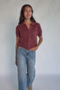 Model wearing a dark clay openwork knit cardigan with a V-neckline, short sleeves, five-button front closure, and a relaxed silhouette.