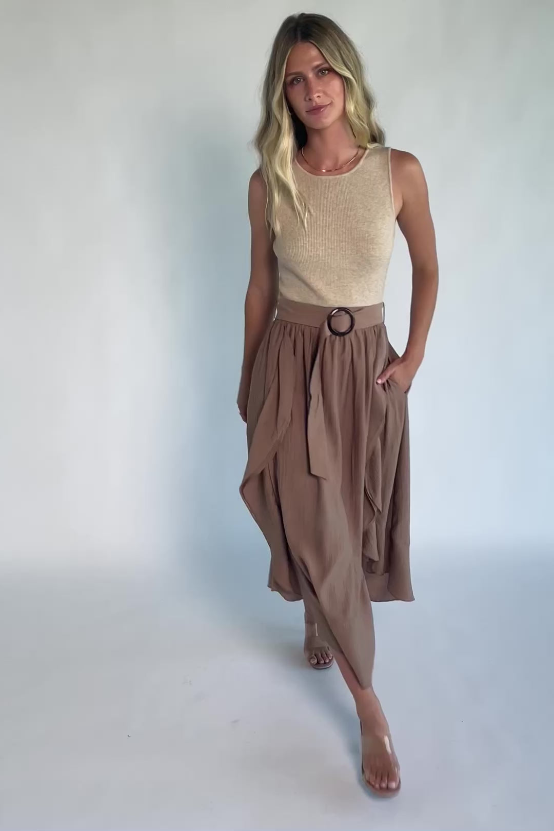 Model wearing the Stacy Midi Dress in Taupe + Mocha featuring a ribbed taupe knit bodice with a bateau neckline and a flowing woven midi skirt.
