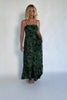 Model wearing a deep olive floral maxi dress with adjustable spaghetti straps, a smocked back bodice with a sash tie, and a flowing tiered skirt.