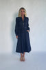 Model wearing a dark chambray midi shirtdress with a collared neckline, half-zip front, long sleeves, and a removable waist sash.