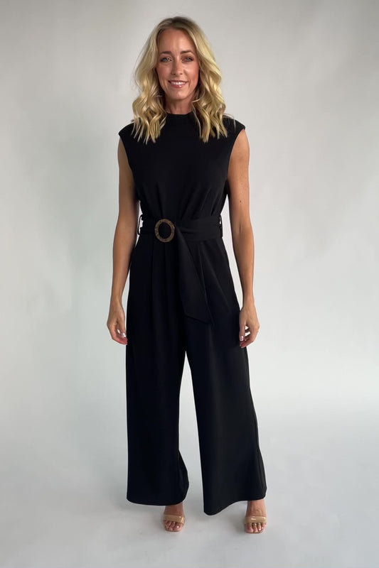 Black tailored wide-leg jumpsuit with a mock neckline, cap sleeves, removable tortoise buckle belt, and side pockets.
