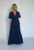 Model wearing a navy chiffon maxi dress with a surplice V-neckline, short ruffled sleeves, and an elastic empire waist.