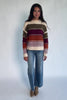 Ivory striped sweater with green, mulberry, rust, and purple horizontal stripes, a round neckline, dropped shoulders, long sleeves, and a relaxed fit.