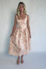 Model wearing a peach floral jacquard midi dress with a square neckline, wide tank straps, and a fitted bodice.