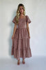 Model wearing a spice and white gingham maxi dress with a square neckline, flutter sleeves, and a fitted bodice with a smocked back
