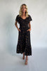 Model wearing a floral midi dress with a smocked bodice, wide V-neckline, and flutter sleeves.