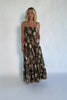 Model wearing an olive floral maxi dress with a square neckline, adjustable spaghetti straps, and a smocked back bodice.