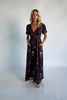 Model wearing a clove floral maxi dress with a deep V-neckline, short sleeves, and an empire waist.