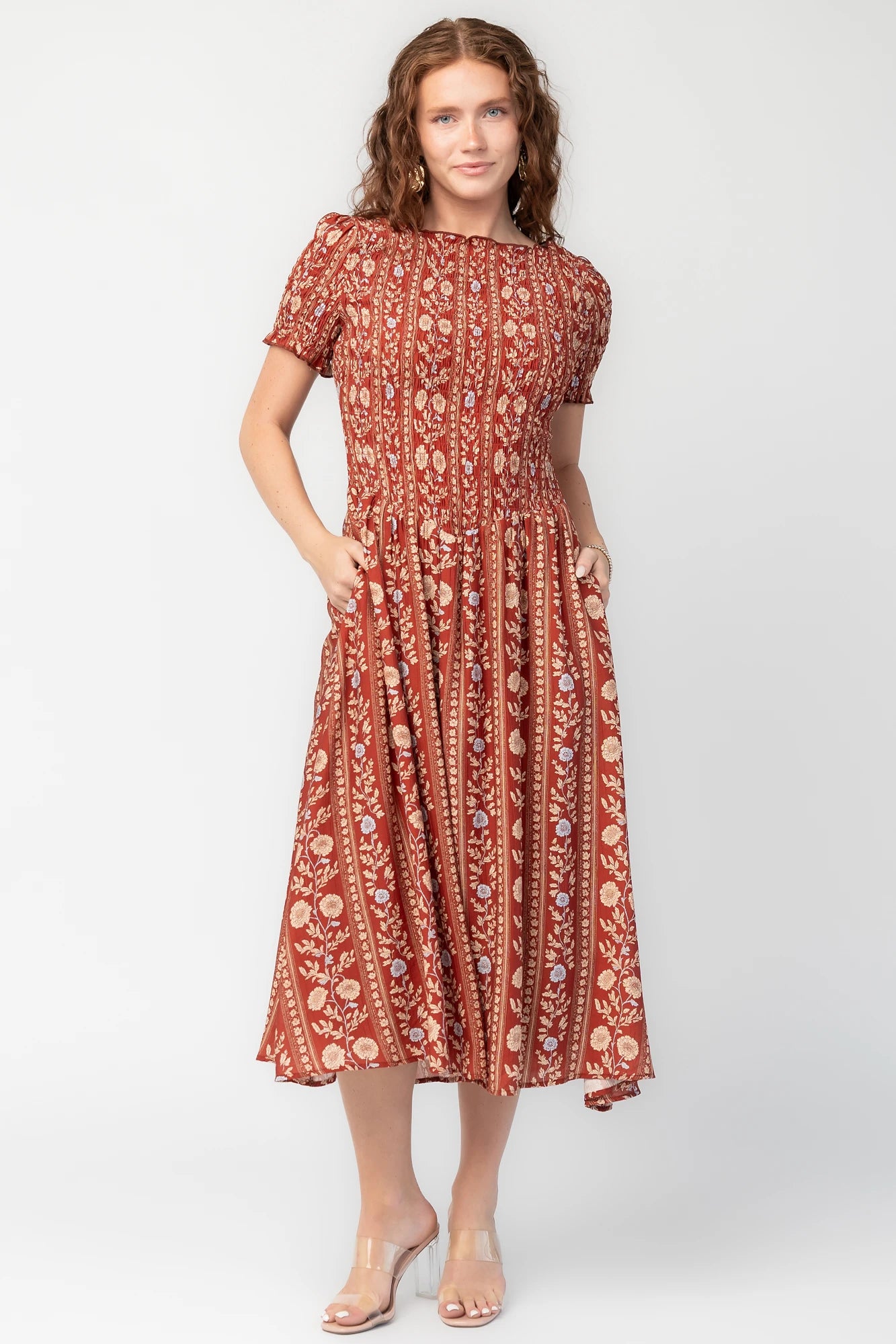 Rhonda Smocked Midi Dress in Rust Print with smocked bodice, short sleeves, round neckline, and gathered skirt.