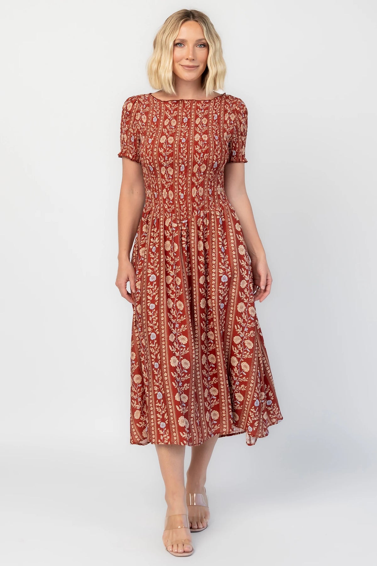 Rhonda Smocked Midi Dress in Rust Print with a round neckline, smocked bodice, and ruffled sleeve edges.