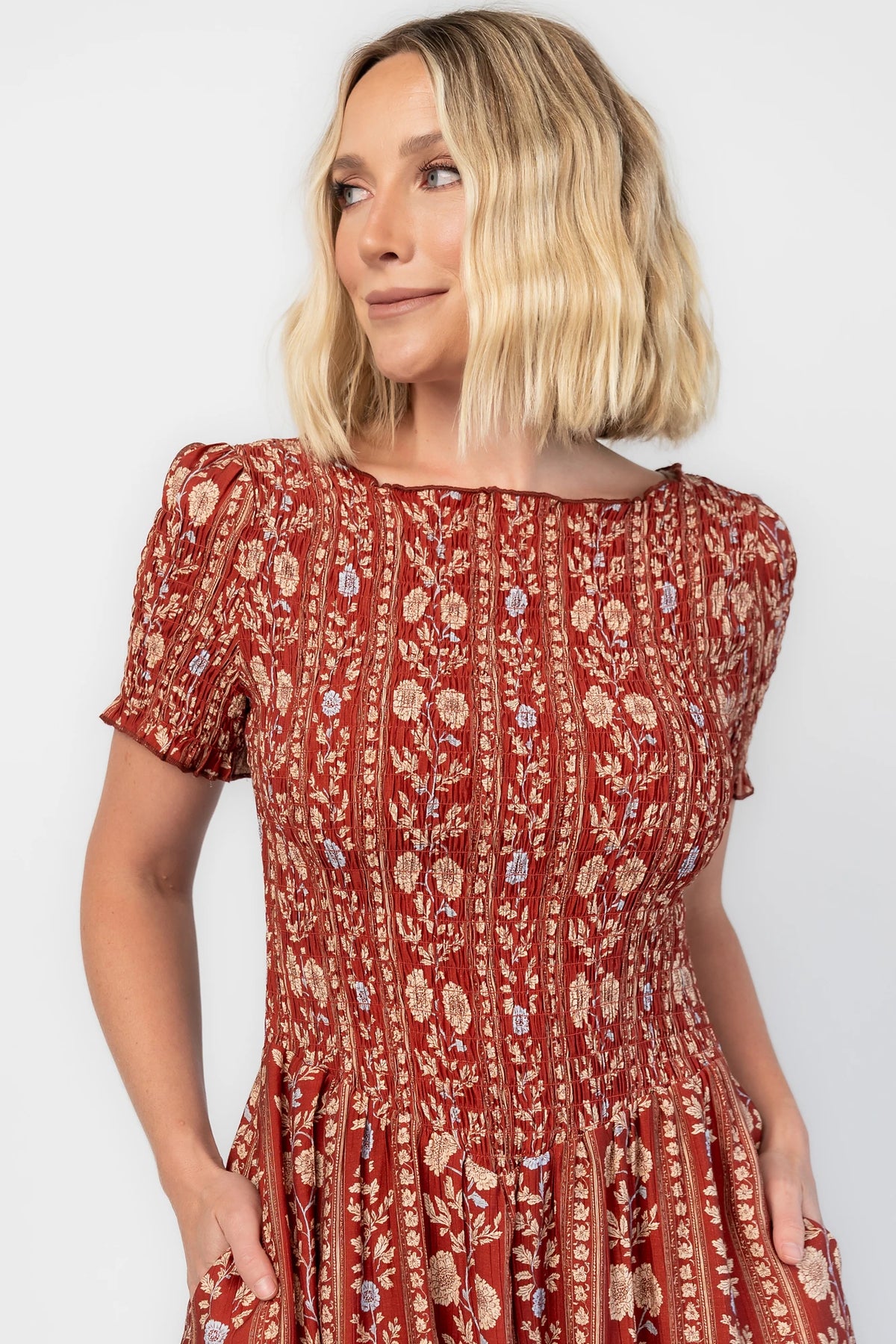 Rhonda Smocked Midi Dress in Rust Print with a round neckline, smocked bodice, and ruffled sleeve edges.
