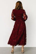 Back view of wine midi dress with elastic waist and removable sash tied, showing lined skirt and flowing tulle layers.